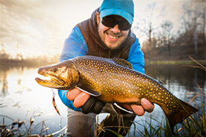 Happy angler with a brook trout